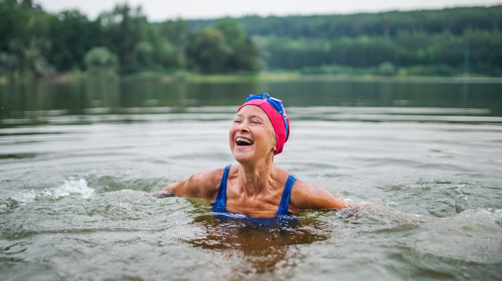 older woman wild swimming in a lake